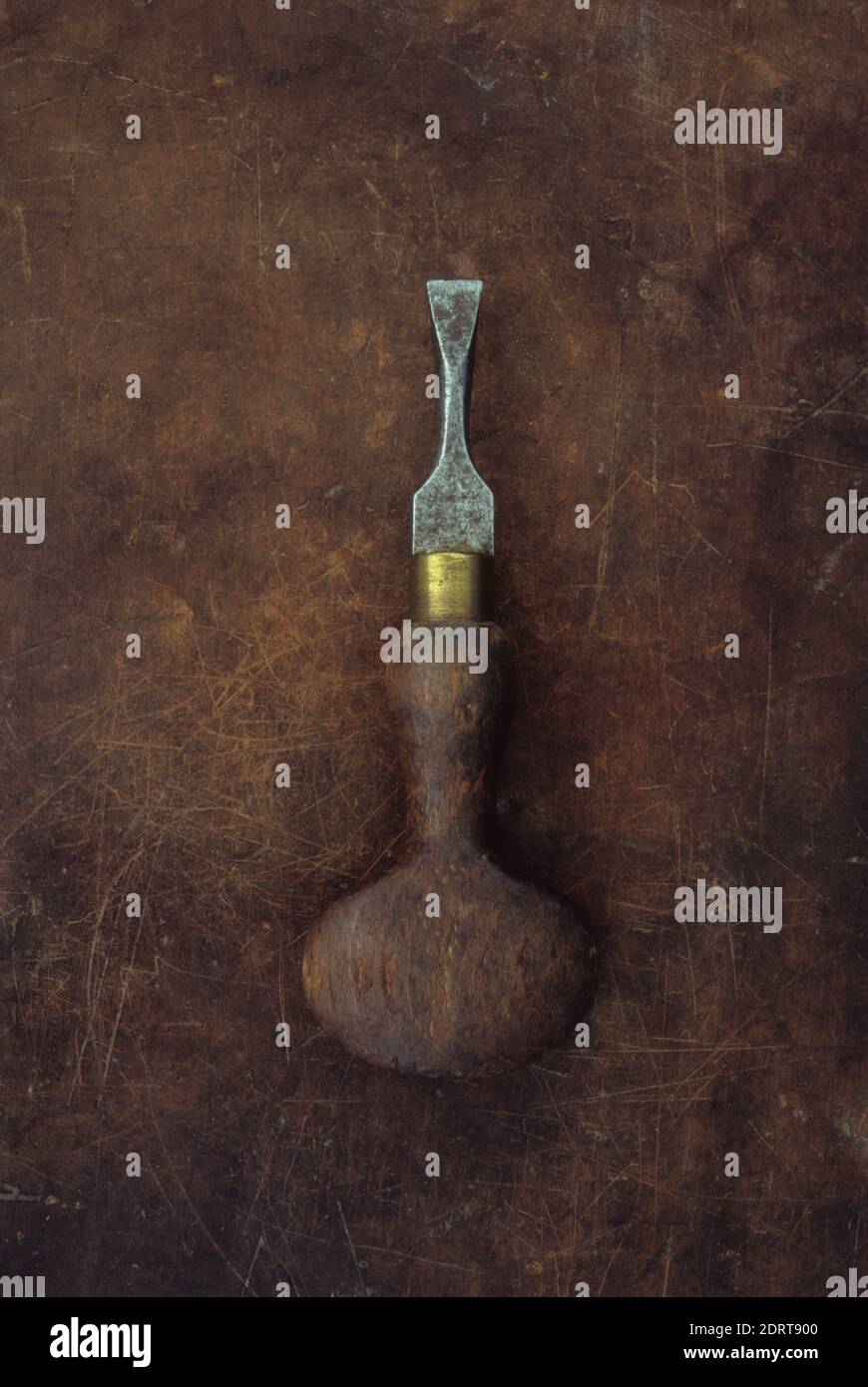 Vintage wellused screwdriver with curvy wooden handle and brass