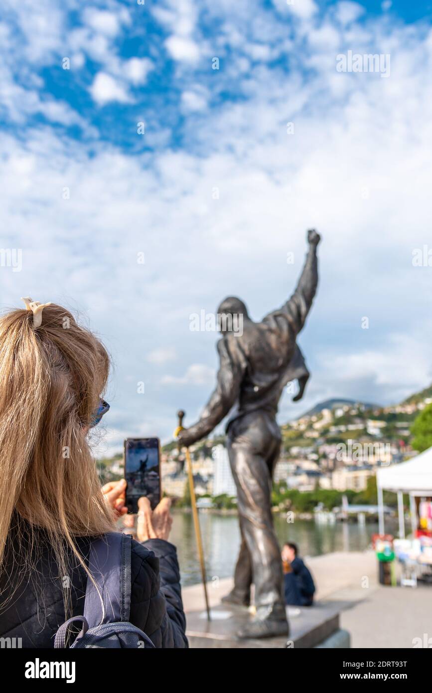 Vertical photo of a blonde woman taking a photograph of a statue of Freddie  Mercury on the shores of Geneve lake in Montreux Stock Photo - Alamy