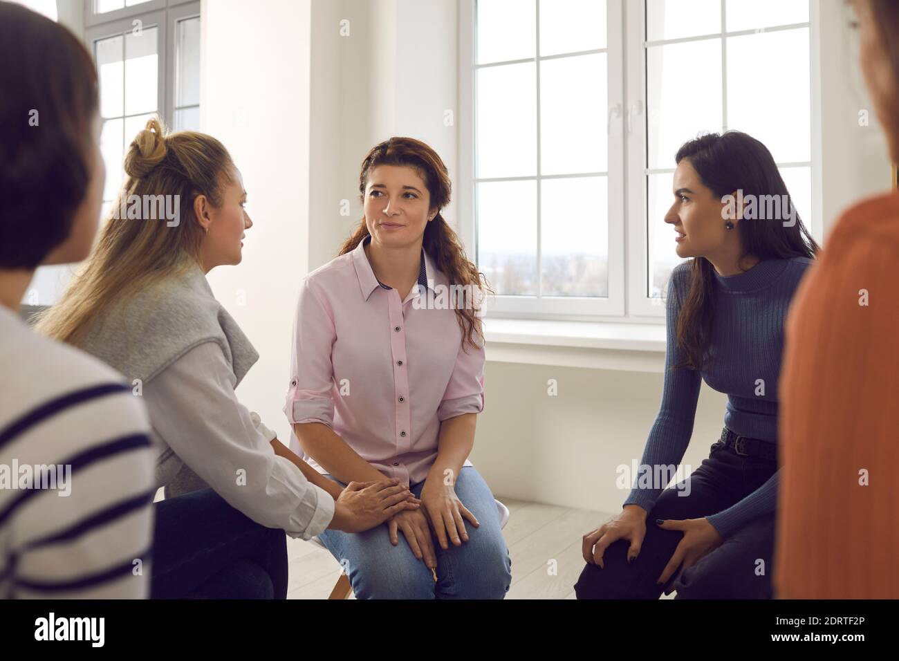 Women talking and helping each other in therapy session or support group meeting Stock Photo