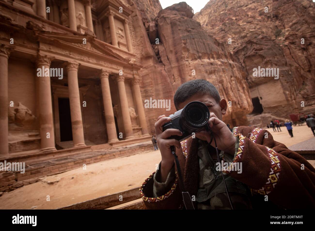 young guy with camera in Wadi Musa, Petra archeological site, just a few weeks  before the global lockdown due to the pandemic Stock Photo