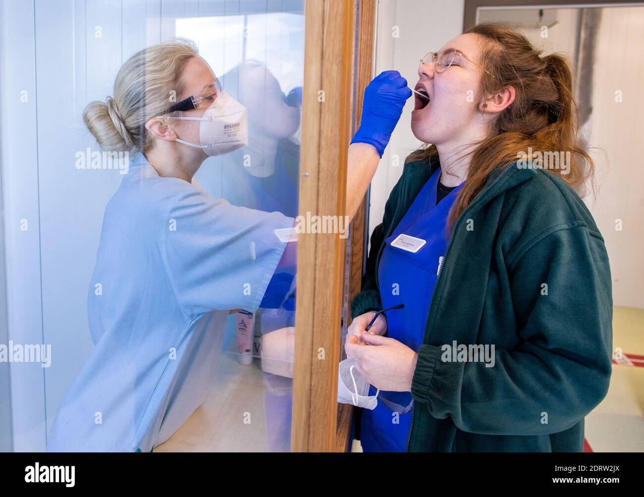 Schwerin, Germany. 21st Dec, 2020. Temporary worker Viviane Kohlhaus takes a swab test from Tessa Boulton at the Corona Testing Centre at Helios Hospital. In addition to patients on admission and residents referred by doctors or the health department, the clinic's employees are also regularly tested for Corona. A new test centre has been operating directly at the Helios Clinic for a few days now. Credit: Jens Büttner/dpa-Zentralbild/dpa/Alamy Live News Stock Photo