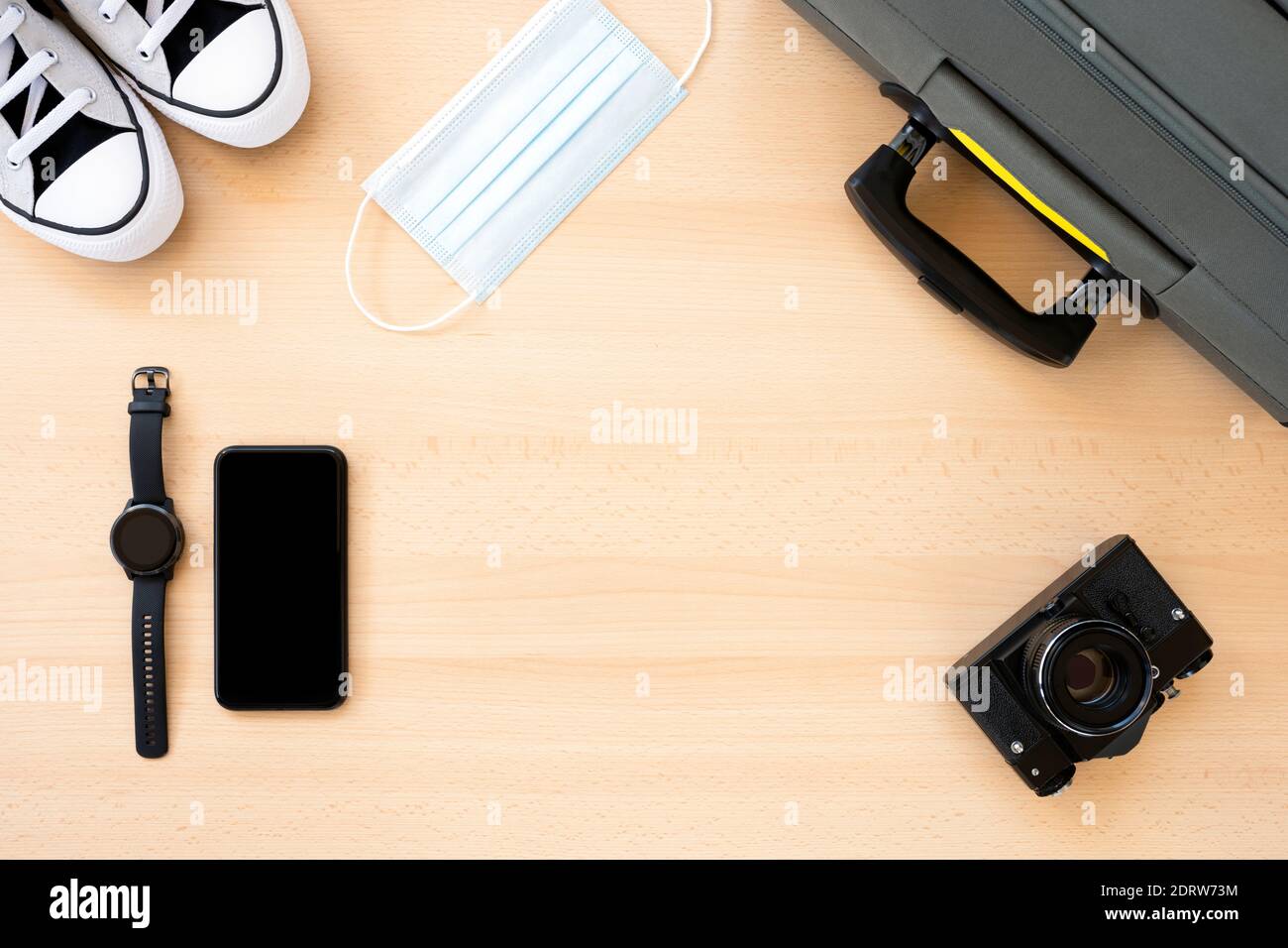 Flat lay with copy space, travel concept during Covid-19 pandemic. Travel accessories on a wooden table. Stock Photo
