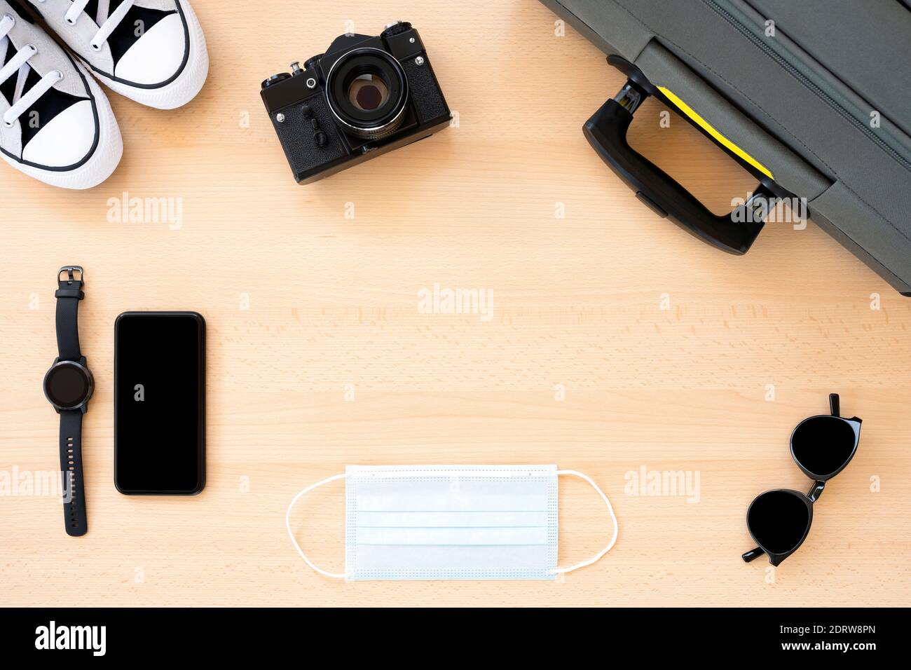 Flat lay with copy space, travel concept during Covid-19 pandemic. Travel accessories on a wooden table. Stock Photo