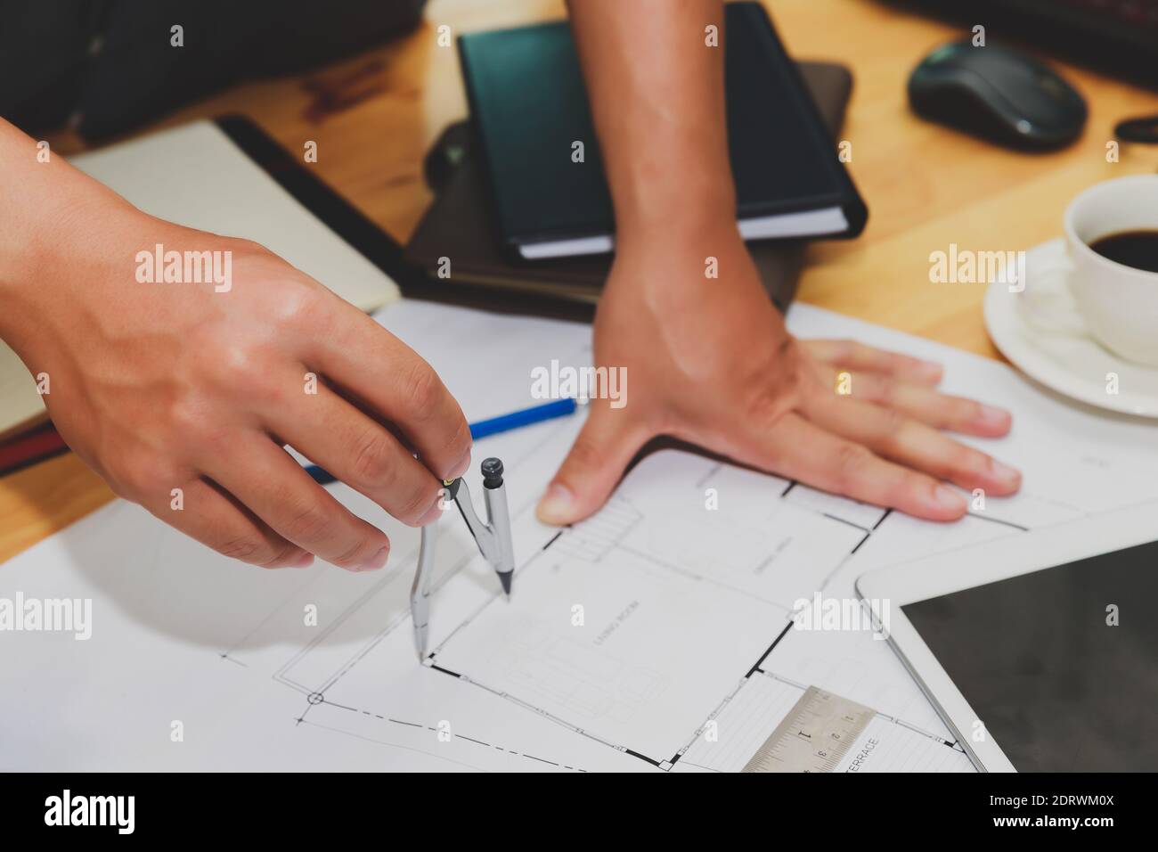 Engineer or architect using divider compass tools on blueprint in office on site. Stock Photo