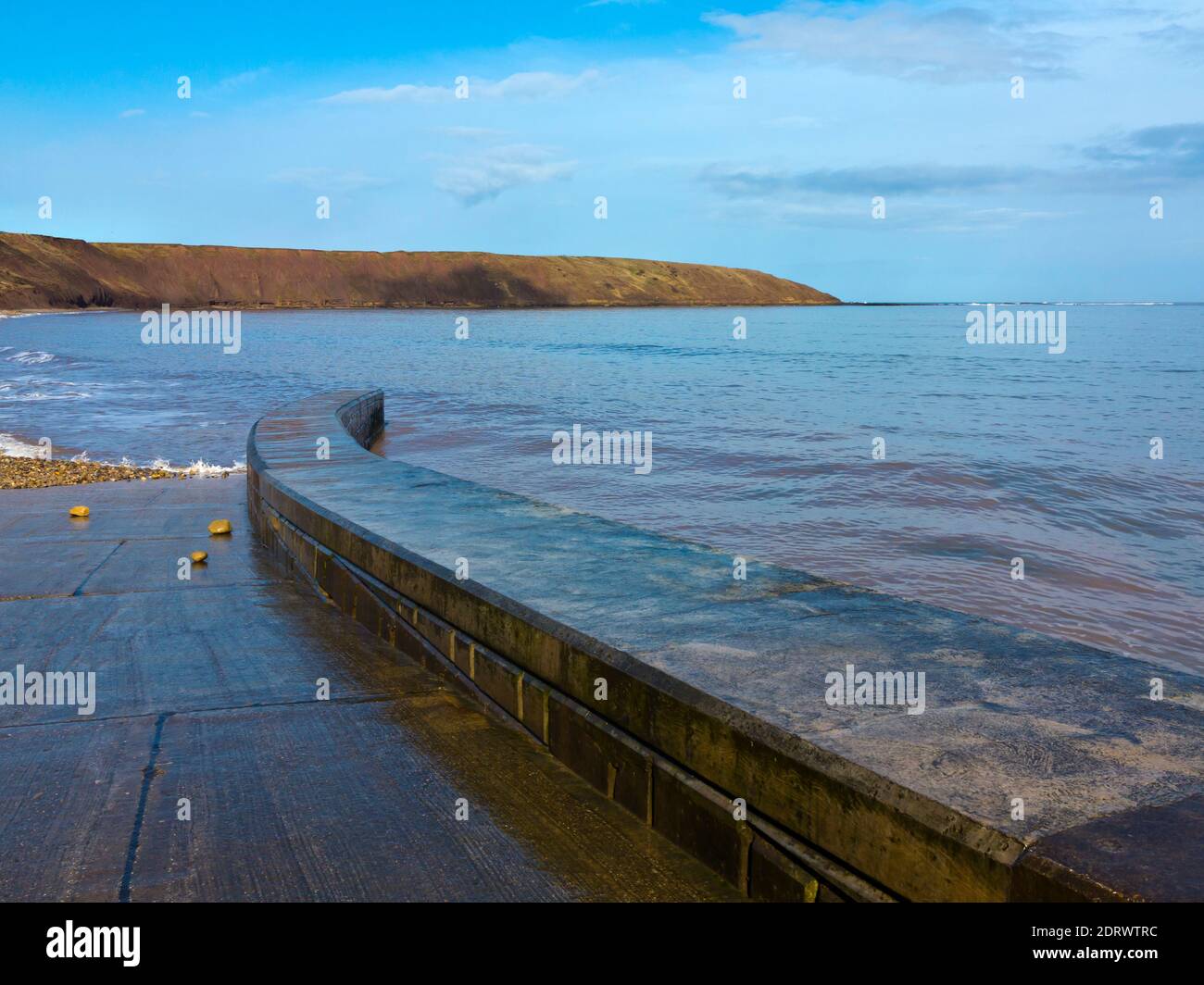 Waves and the promenade at high tide on the beach at Filey a popular seaside resort on the North Yorkshire coast in northern England UK Stock Photo