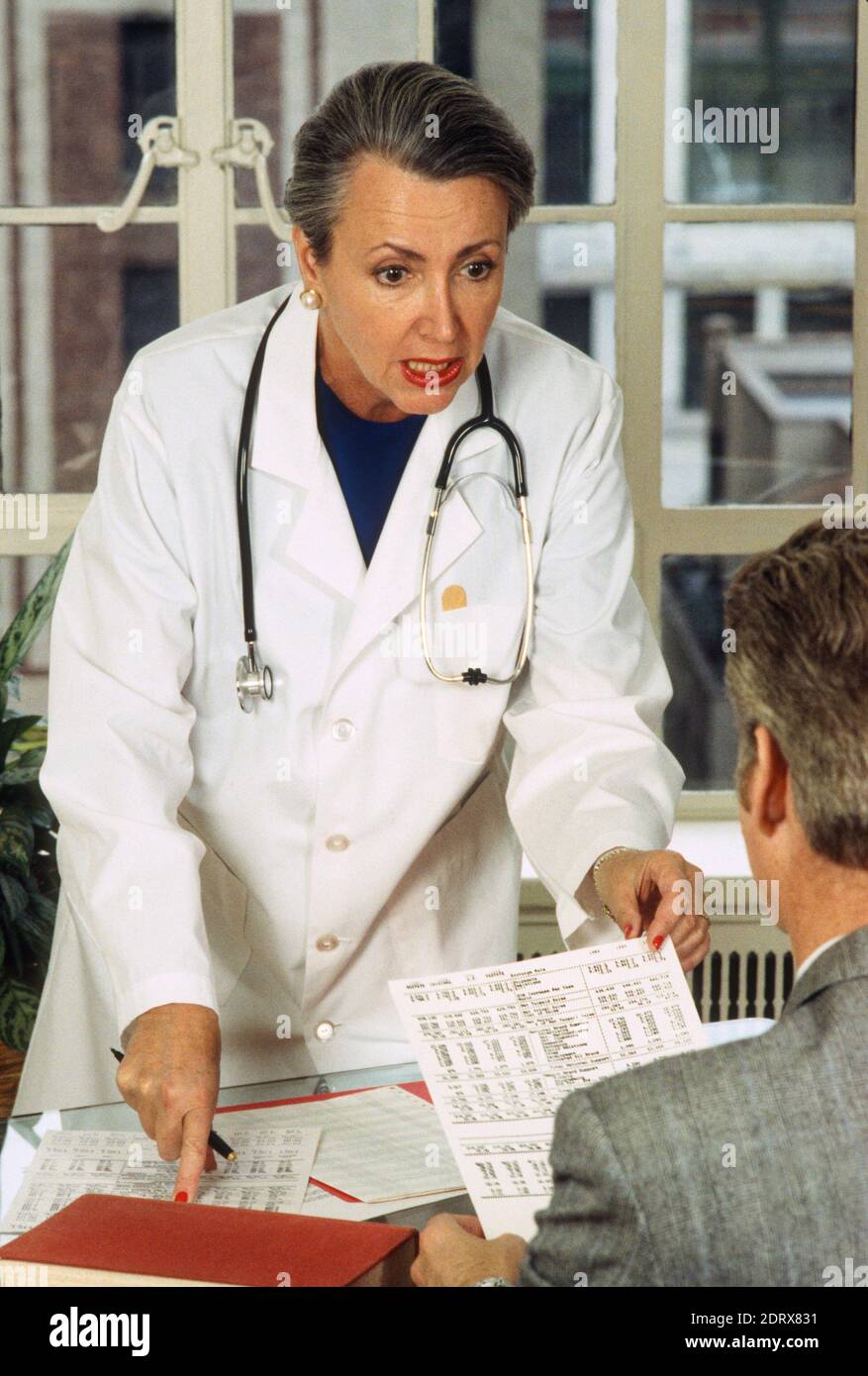 1994, Female Doctor Reviews Lab Results with a Male Patient., USA Stock Photo