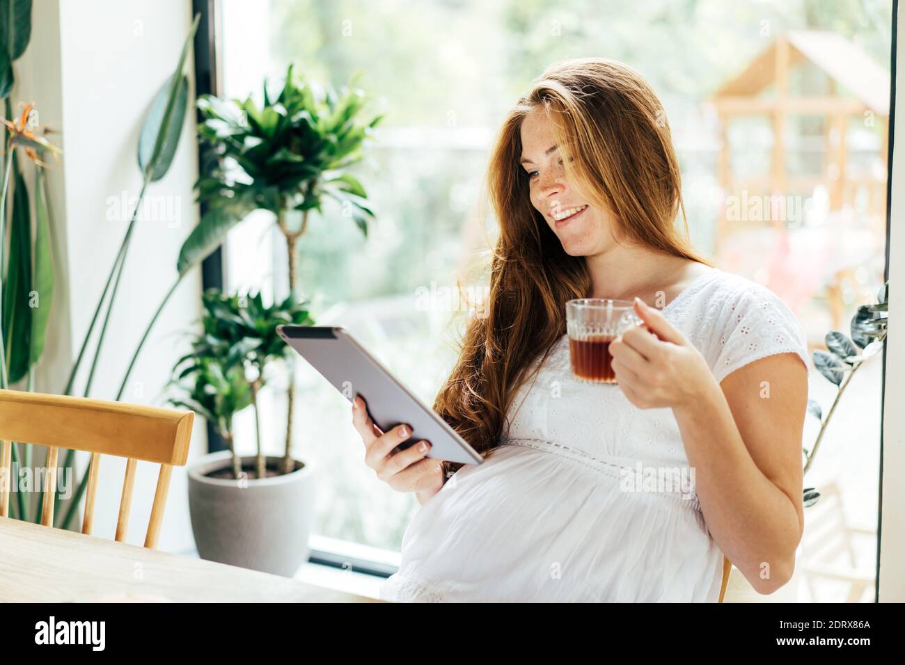 Charming pregnant woman drinks a drink Stock Photo Alamy