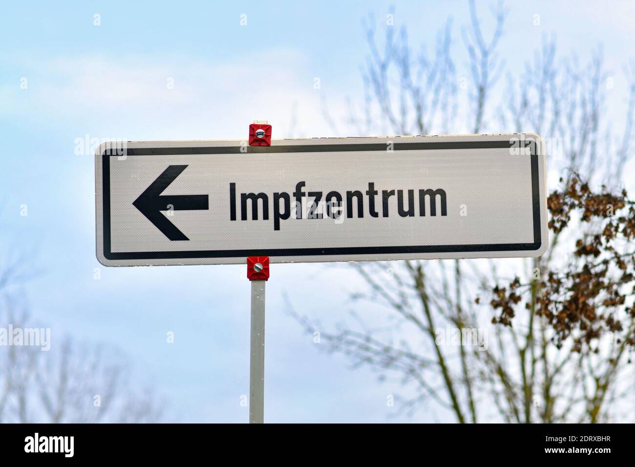 Road sign pointing towards German vaccination center called 'Impfzentrum' set up to vaccine people against Corona virus in Heidelberg Stock Photo