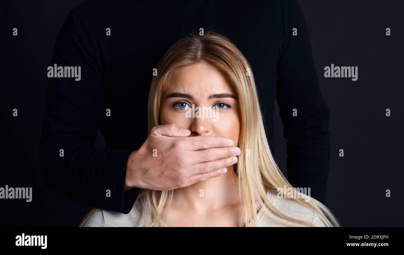 Shut up and listen. Male hand closes woman mouth and prevents her from talking about feelings Stock Photo