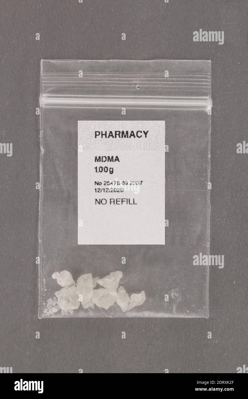 MDMA crystals in plastic bag with pharmacy label. Alternative psychotherapy. Prescription drugs. Stock Photo