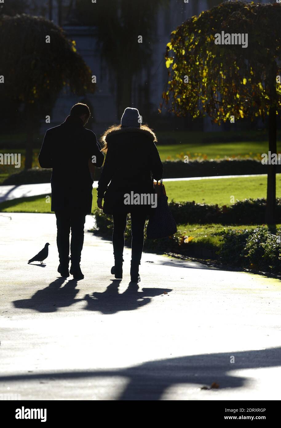 London, England, UK. Man and woman walking through Victoria Embankment Gardens, Dec 2020 Stock Photo