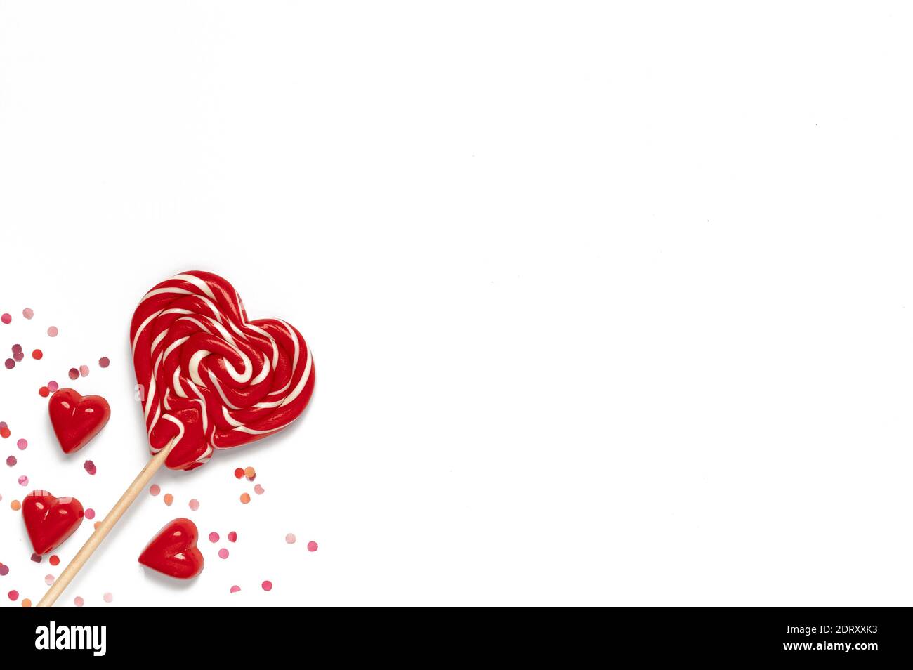 Red sweet tasty lollipops and chocolate candies in shape of heart with