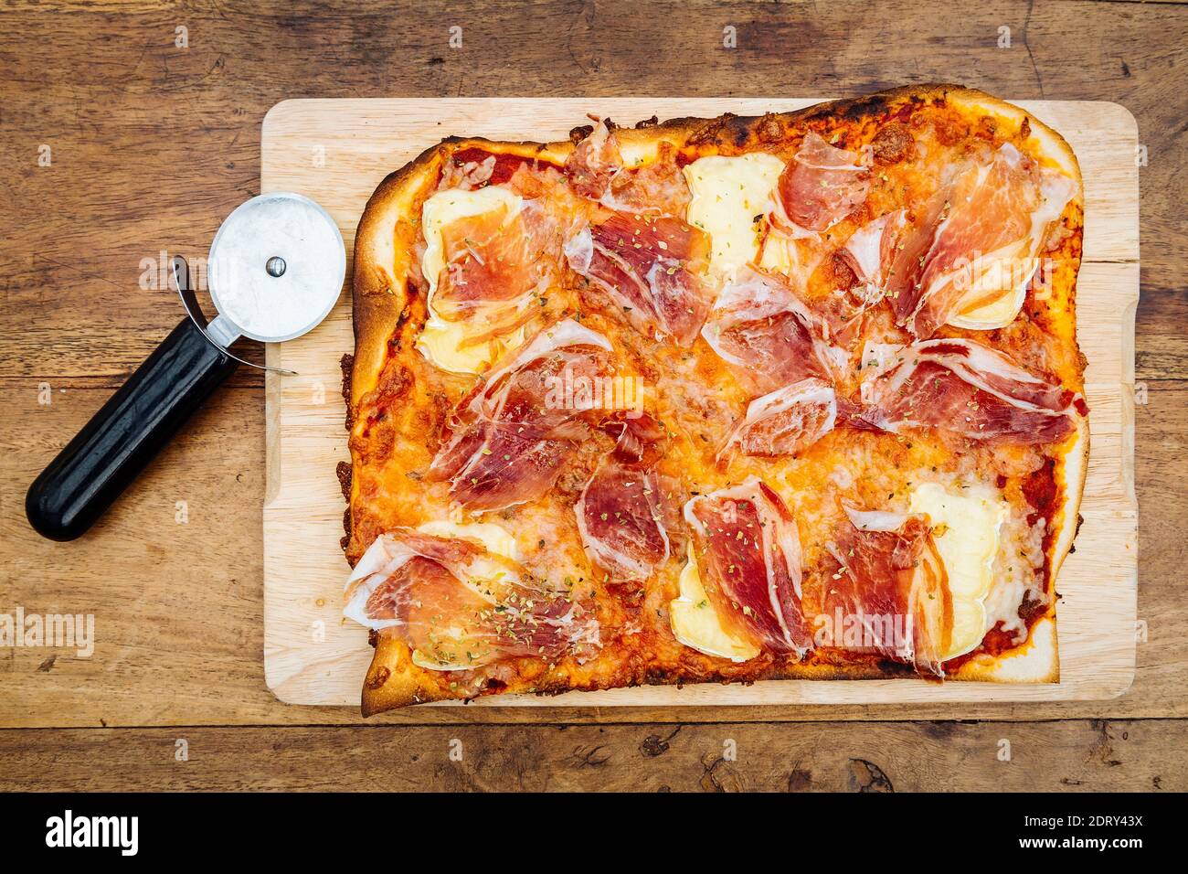 Traditional ham and brie cheese pizza on wood plank Stock Photo Alamy