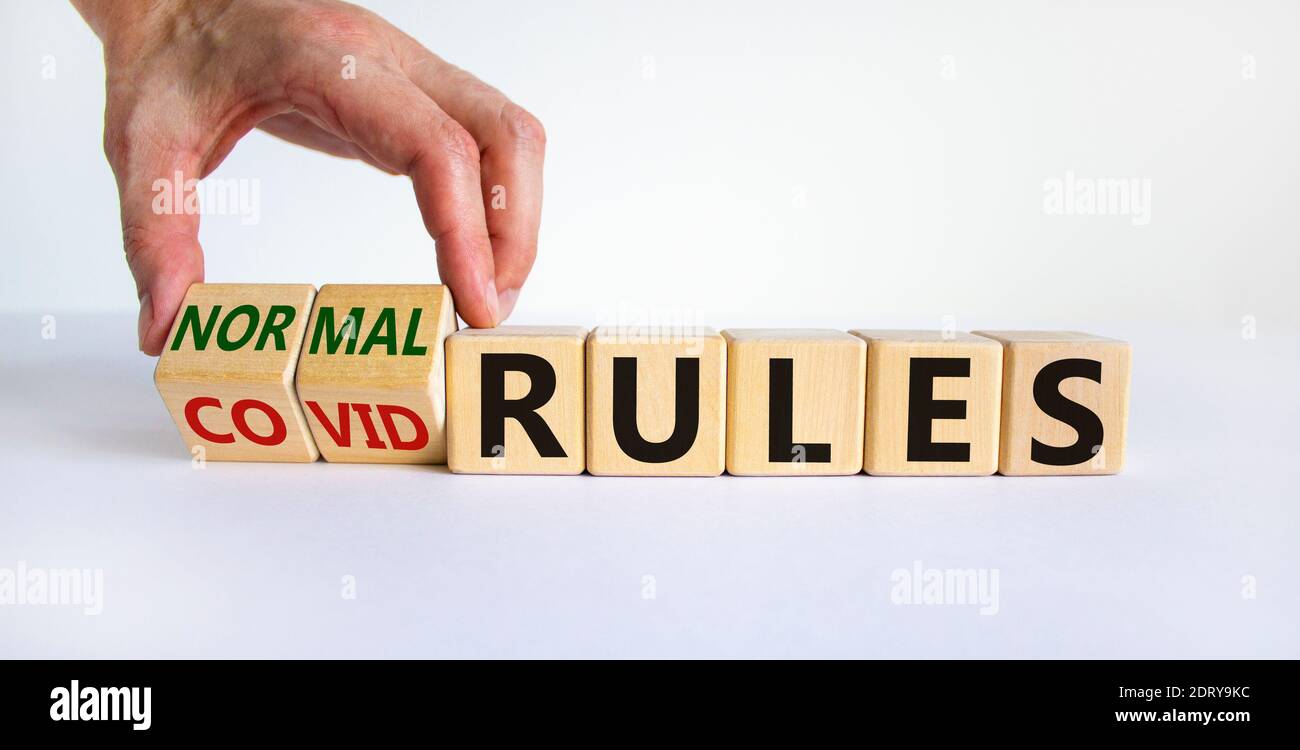 Normal Rules Covid rules symbol. Hand turns cubes and changes words 'covid rules' to ...