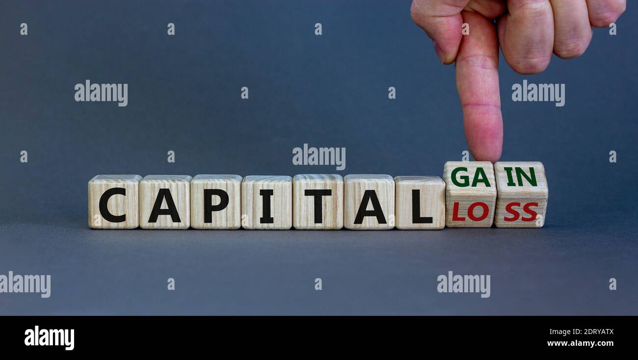 Capital loss or gain symbol. Male hand turns cubes and changes words ...