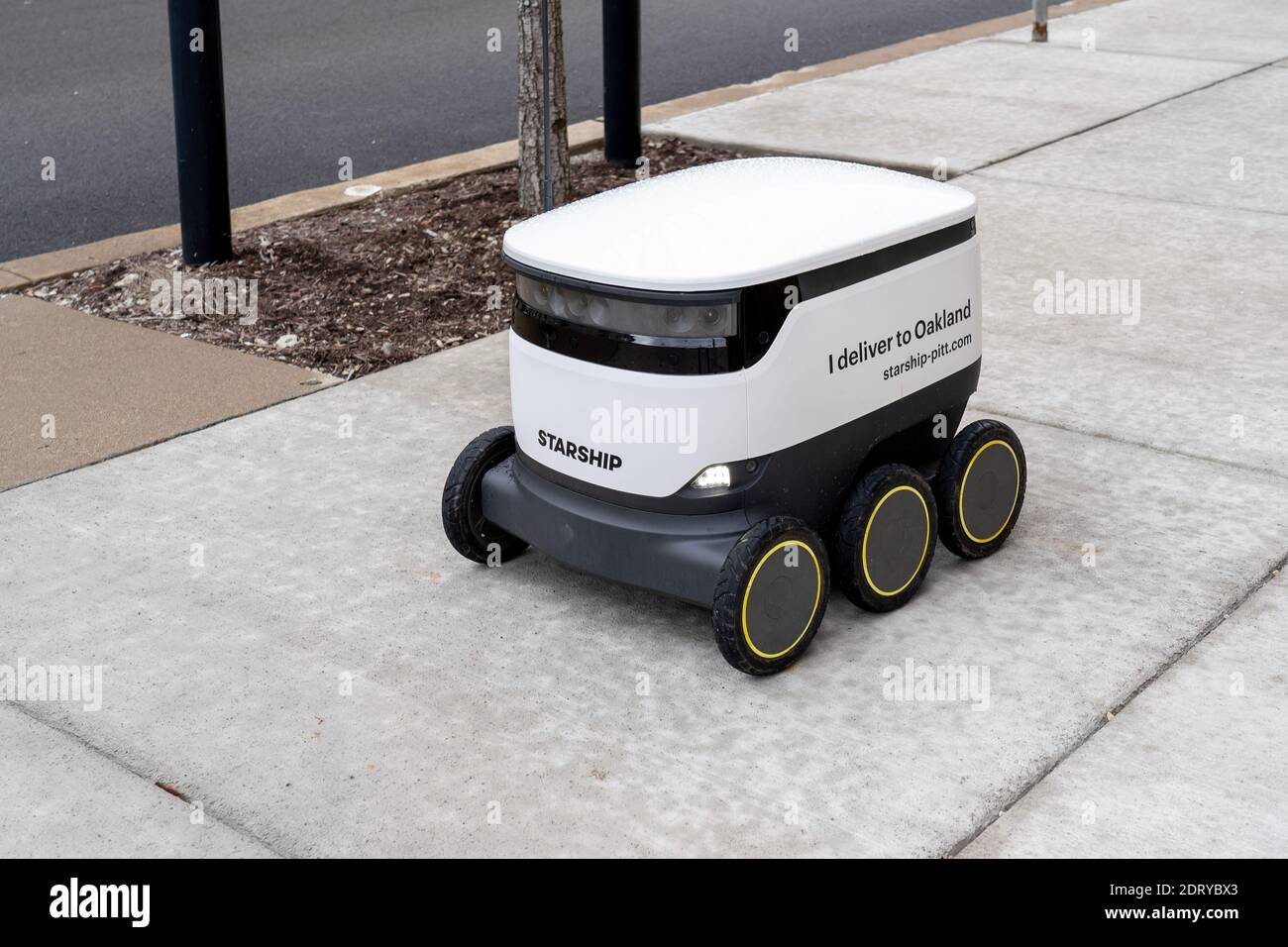 A Starship food delivery robot is driving on the sidewalk in University of Pittsburgh campus in Pittsburgh, PA, USA. Stock Photo