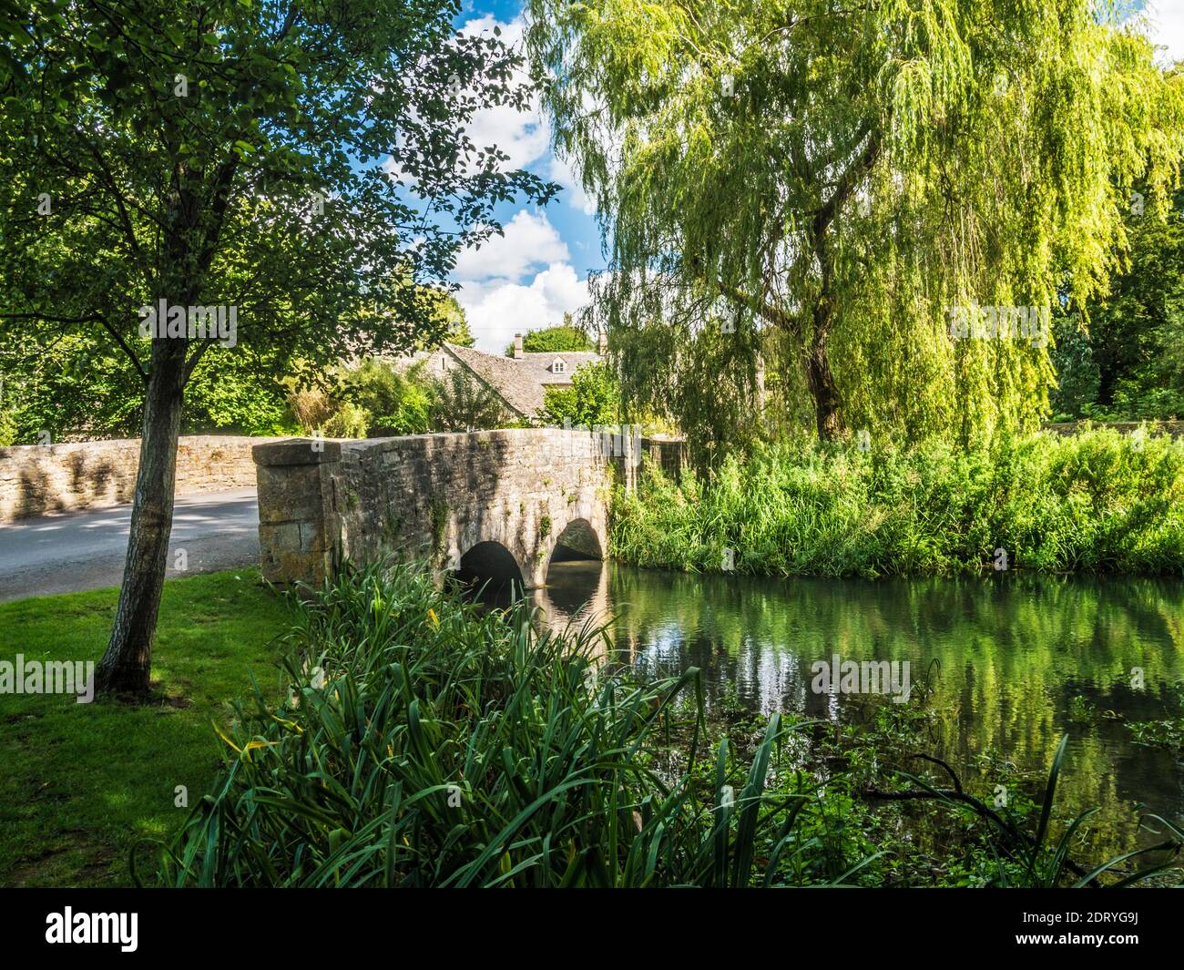 The pretty stone bridge over the River Coln at Ablington in the Gloucestershire Cotswolds. Stock Photo