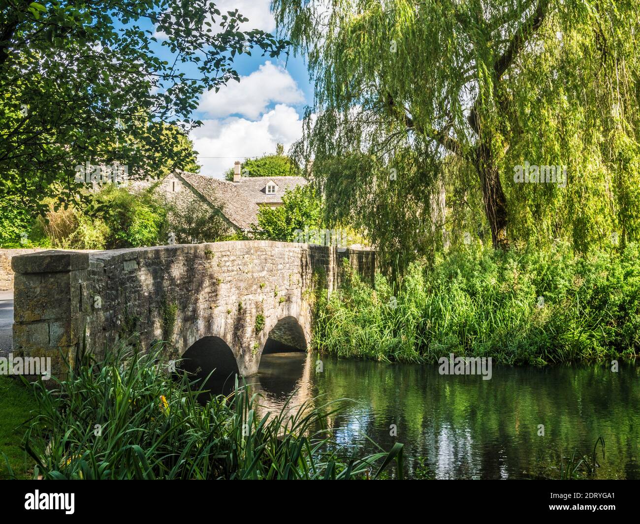 The pretty stone bridge over the River Coln at Ablington in the Gloucestershire Cotswolds. Stock Photo
