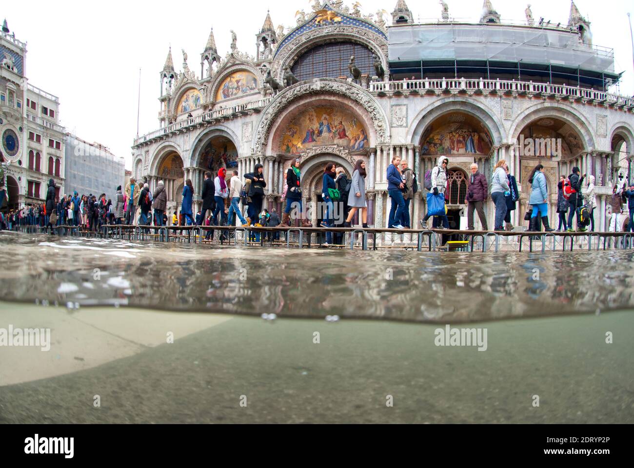 Underwater photo St. Mark's Square flooded by high tide with people walking by. Venice, Italy Stock Photo