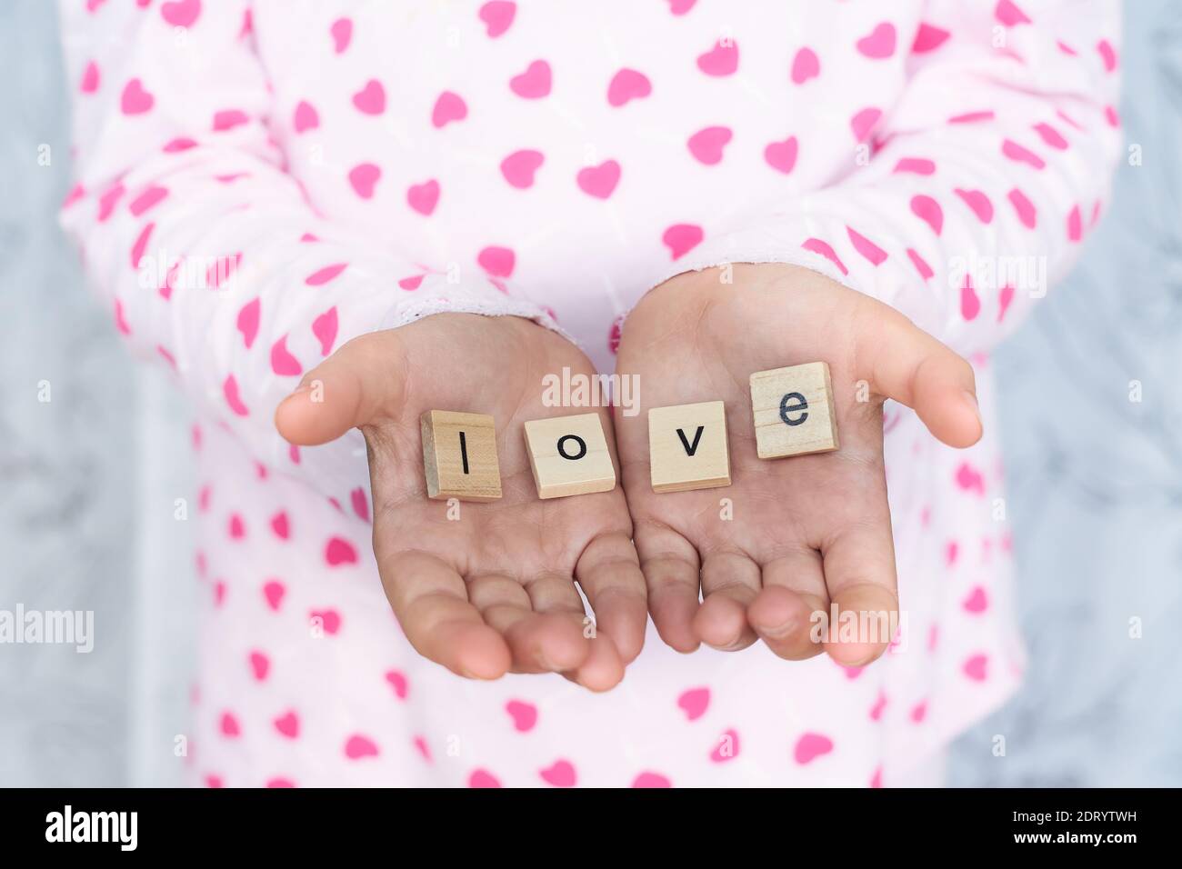 girl holds the word love in her hands , selective focus Stock Photo