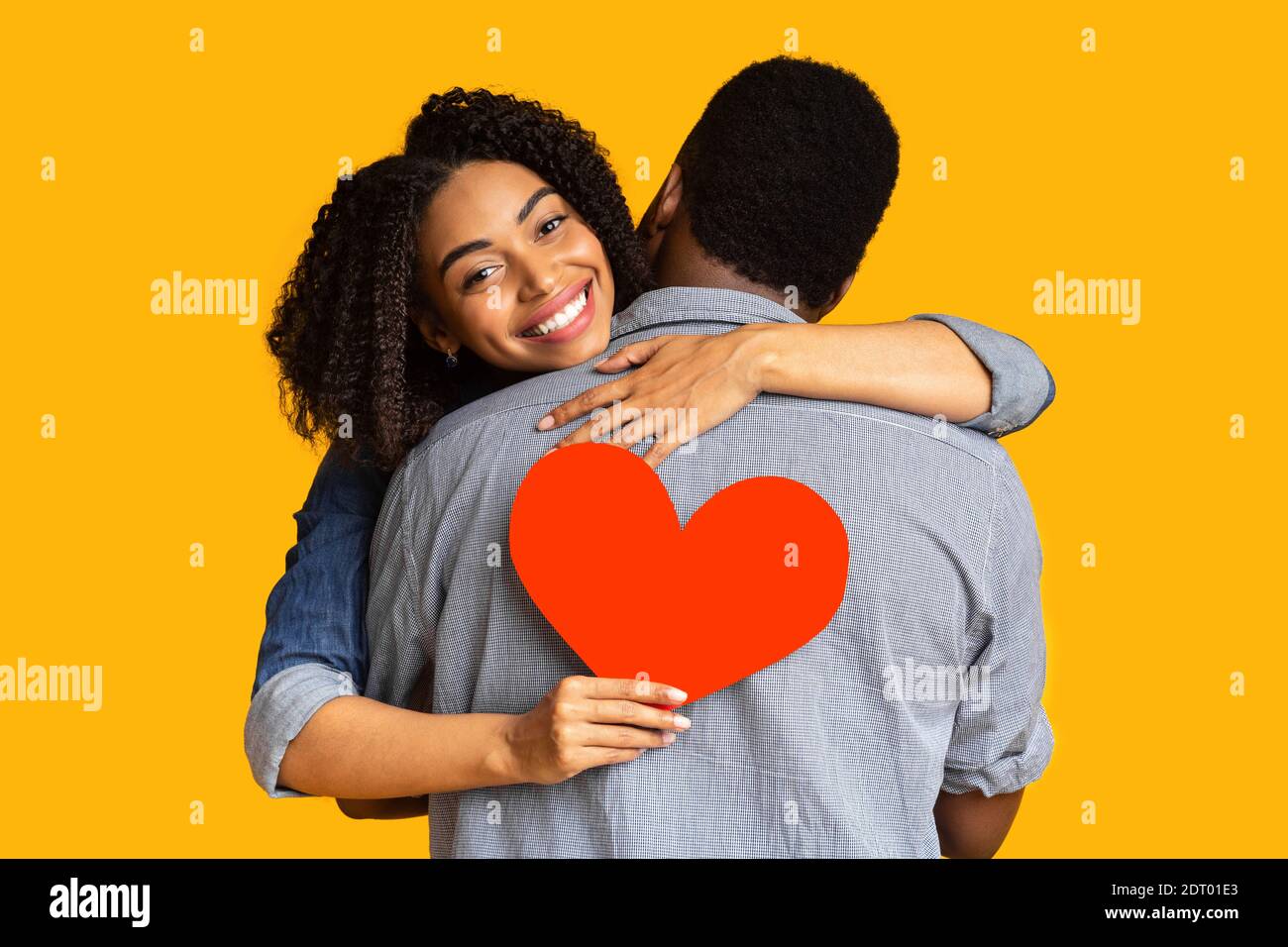 Happy african american woman in love hugging boyfriend and holding red ...