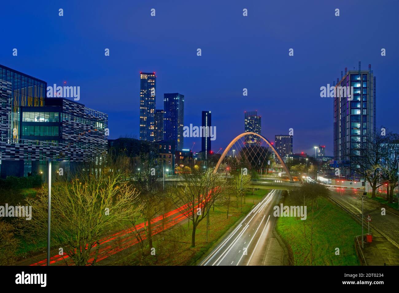 Modern 2021 Manchester skyline from south with Hulme Arch featuring and part of Manchester Metropolitan University on left. Stock Photo
