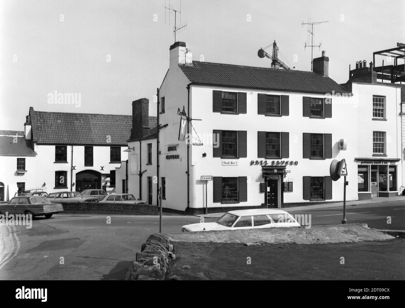 The Pall Tavern, Yeovil in or just before 1975. Earlier this was the Pall Hotel run by Brutton's Beers, her it is the Pall Tavern, a Berni Inn (There is the iconic Berni Inn wine glass next to the words 'Steak Bar' and a Berni projector above the two-way traffic sign). It is believed that under Bass it remained as the Pall Tavern as it is today (2020) and still going strong. Pall Tavern Yeovil in 1975 number 0285 Stock Photo