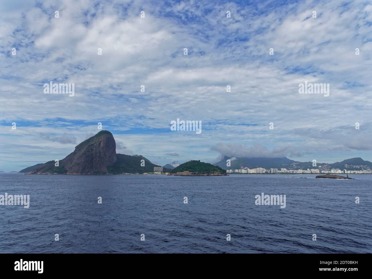 Copacabana beach visible from a Vessel heading in to the Port of Rio, overlooked by the dramatic mountain of Pedra da Gavea. Stock Photo