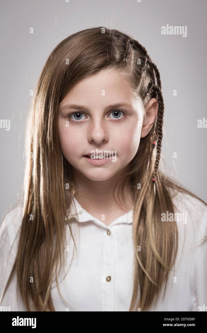 Studio portrait of a cute girl with long blonde hair wearing a white ...