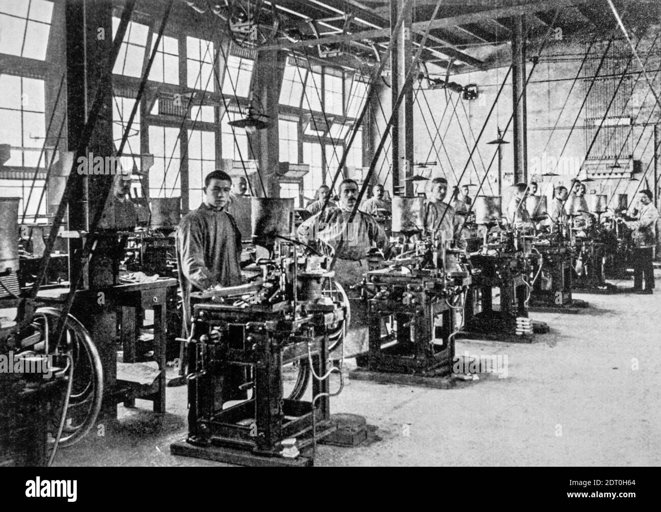 Early 20th century black and white archival photo showing workers and machines for casting types for typesetters at foundry floor of type foundry Stock Photo