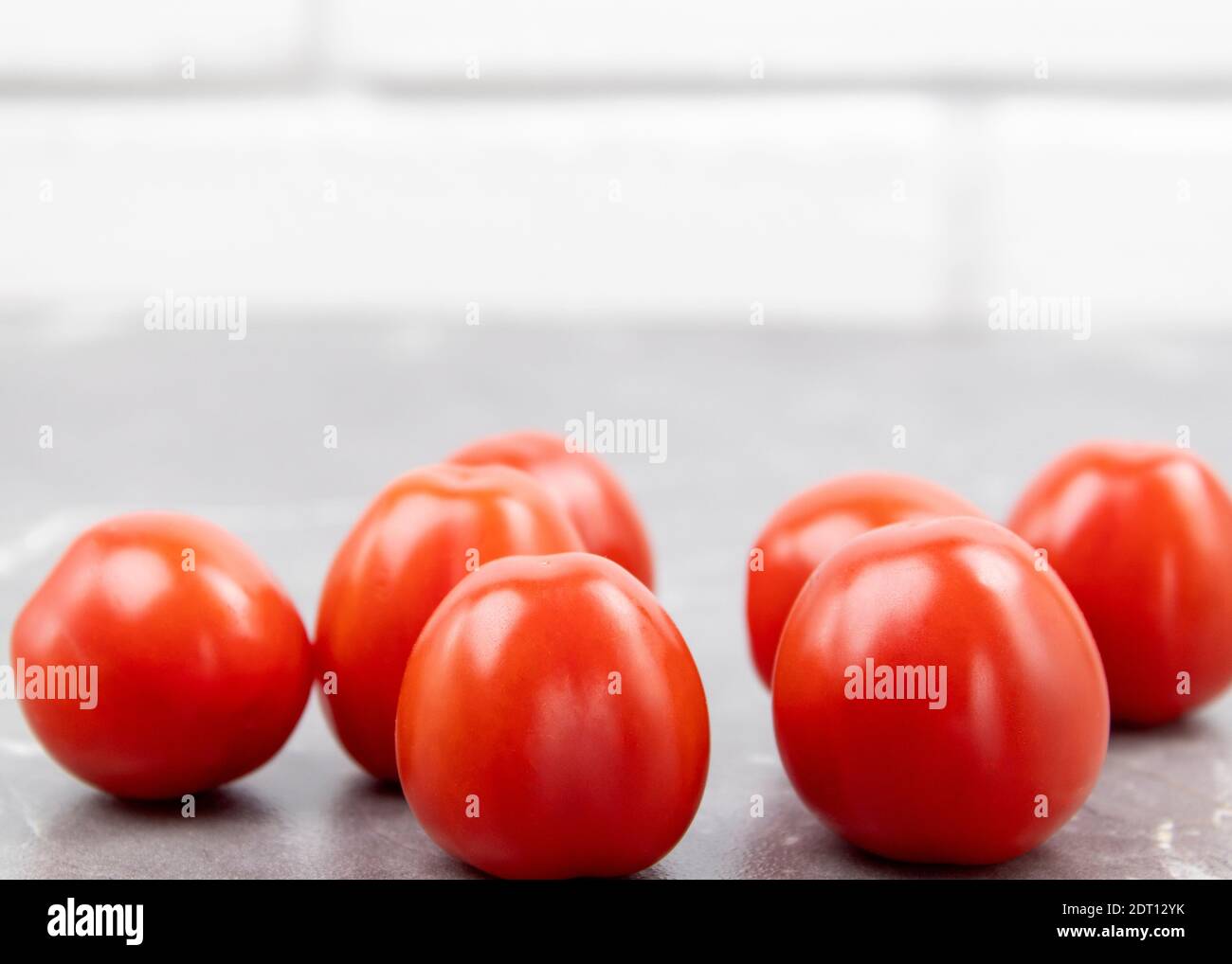 Cherry tomatoes on a marble table. Freshly picked small tomatoes. Fresh and healthy vegetables as background with place for text Stock Photo
