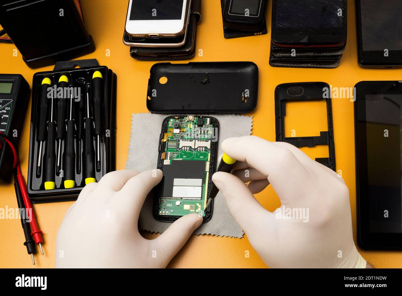 Dismantling an old telephone with a screwdriver for repair and cleaning