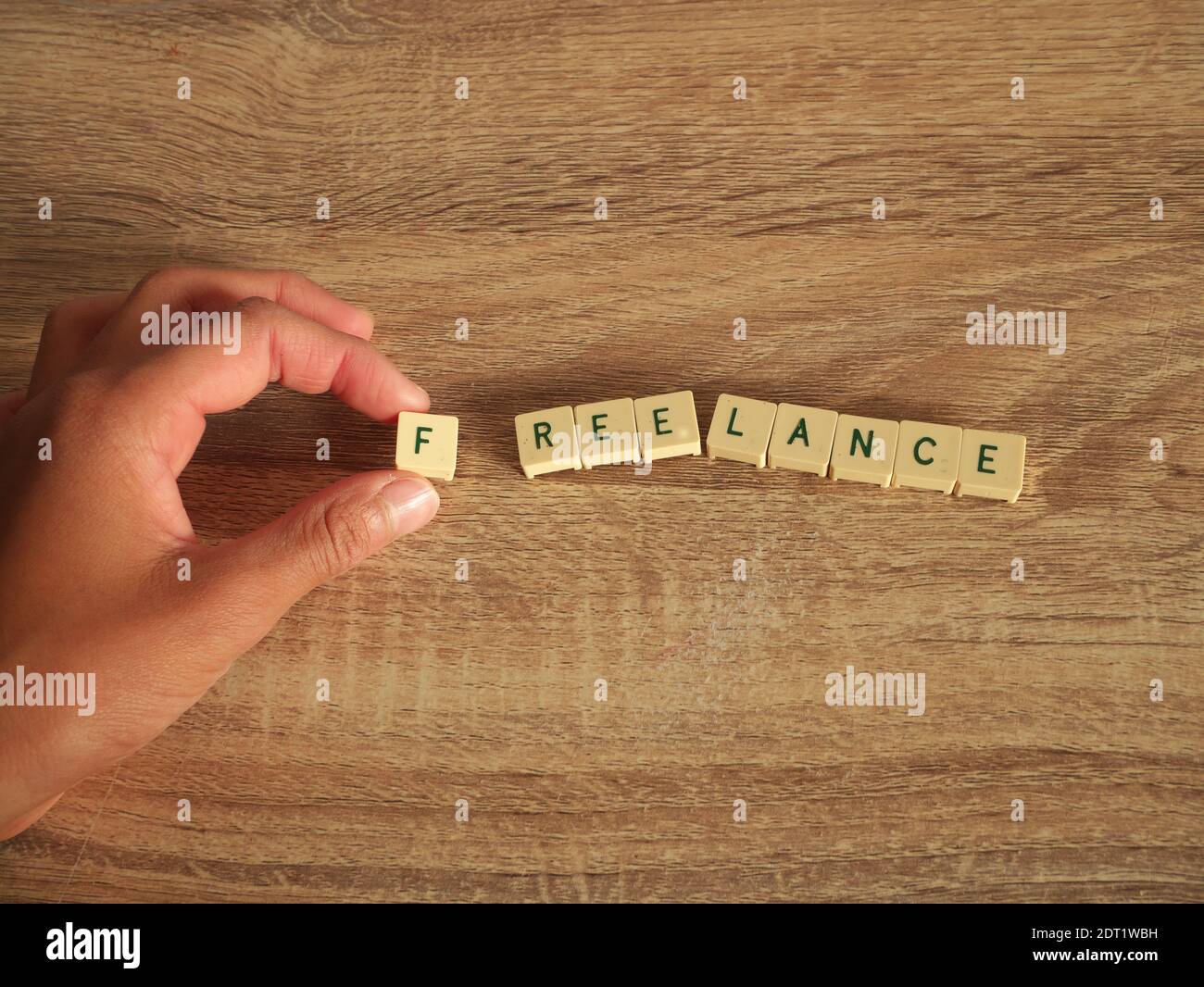 Hand is placing the FREELANCE with scrabble letters Stock Photo