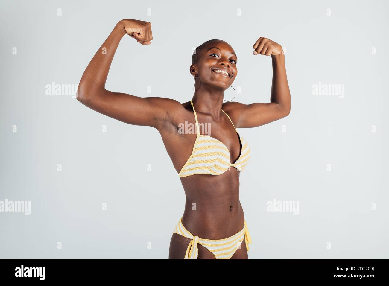 Young woman wearing bikini, flexing muscles Stock Photo
