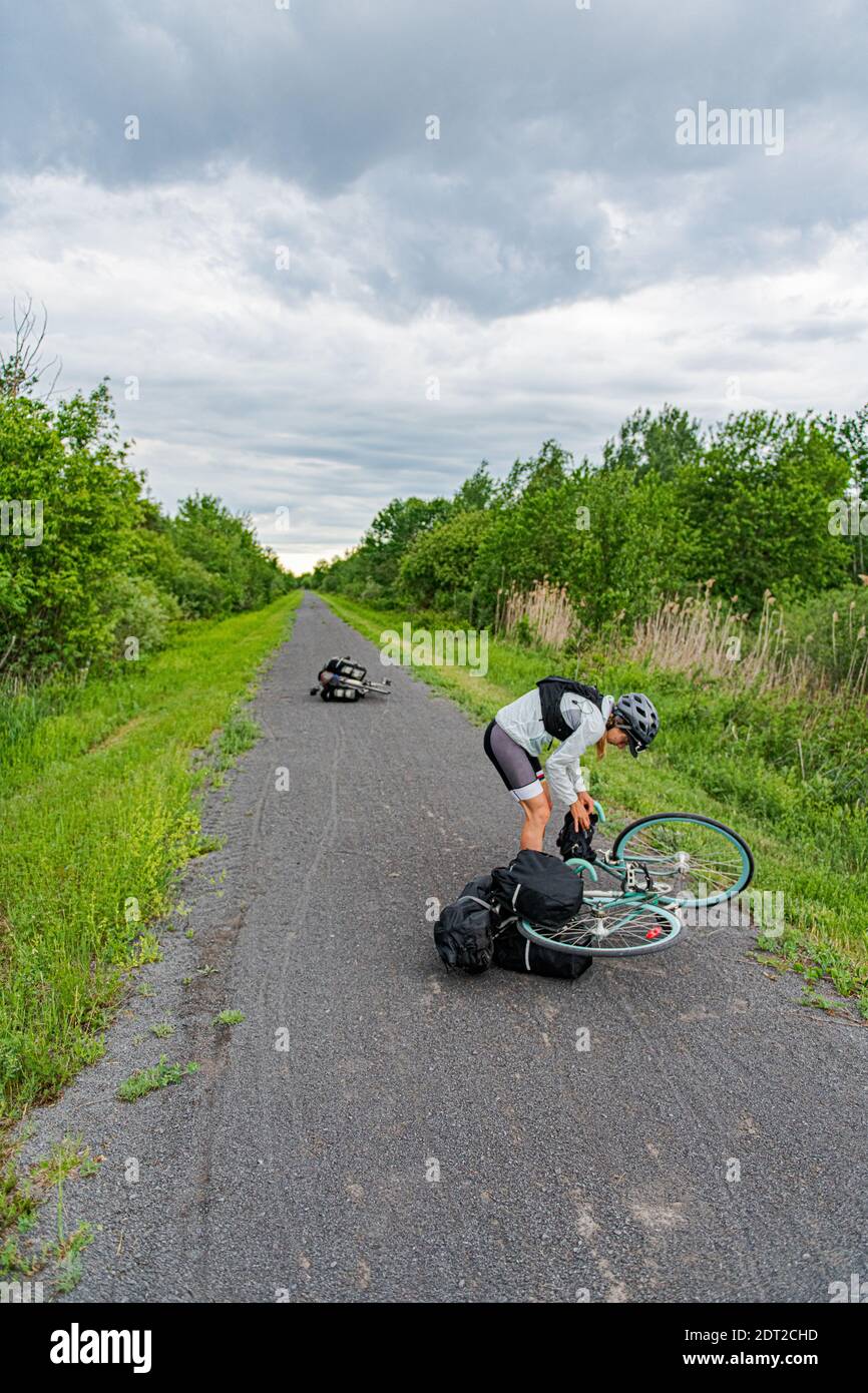 Cyclist picking up bike from road, Ontario, Canada Stock Photo