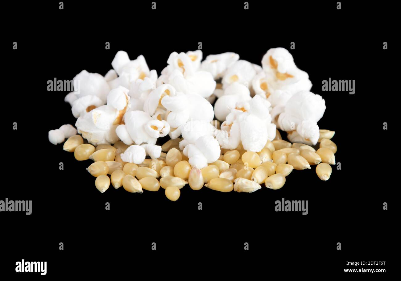 Popping corn and popped kernels on a black background Stock Photo