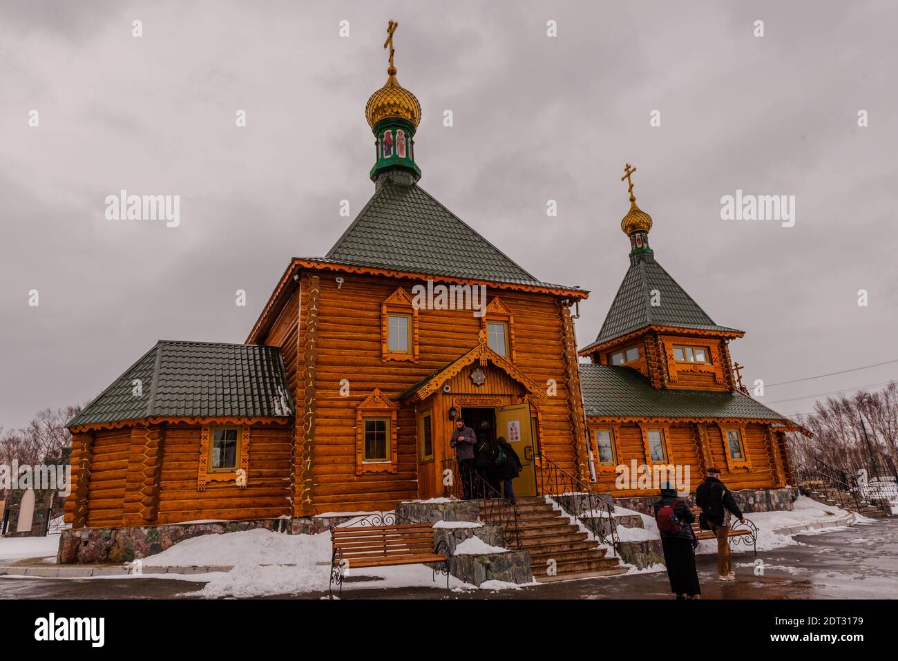 Korsakov, Russia -- April 17, 2016. Tourists visit a traditional Russian Orthodox Church in Korsakov on a gray snowy day. Stock Photo
