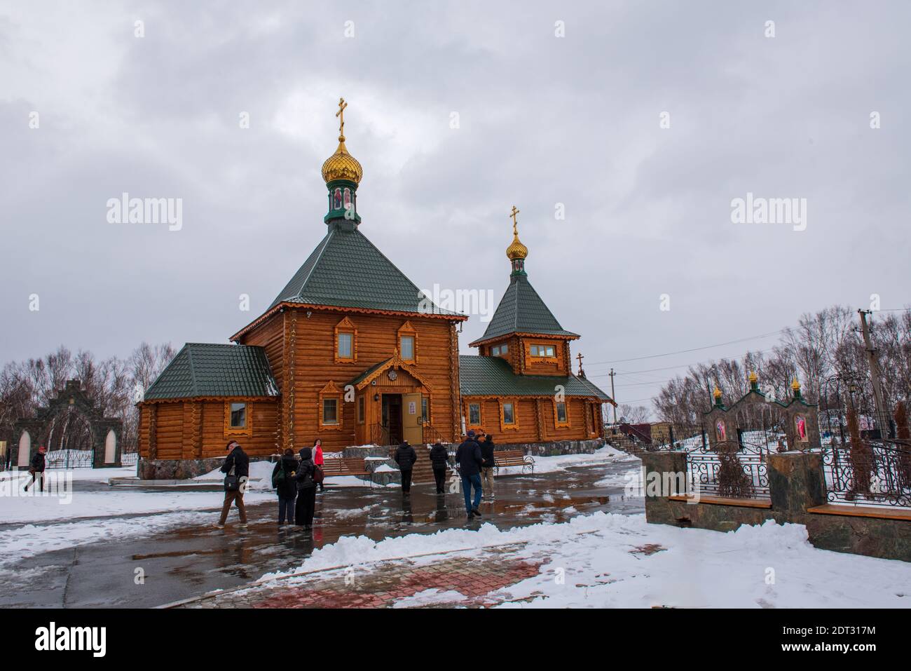 Korsakov, Russia -- April 17, 2016. A wide angle photo of tourists visiting a traditional Russian Orthodox Church in Korsakov on a gray snowy day. Stock Photo