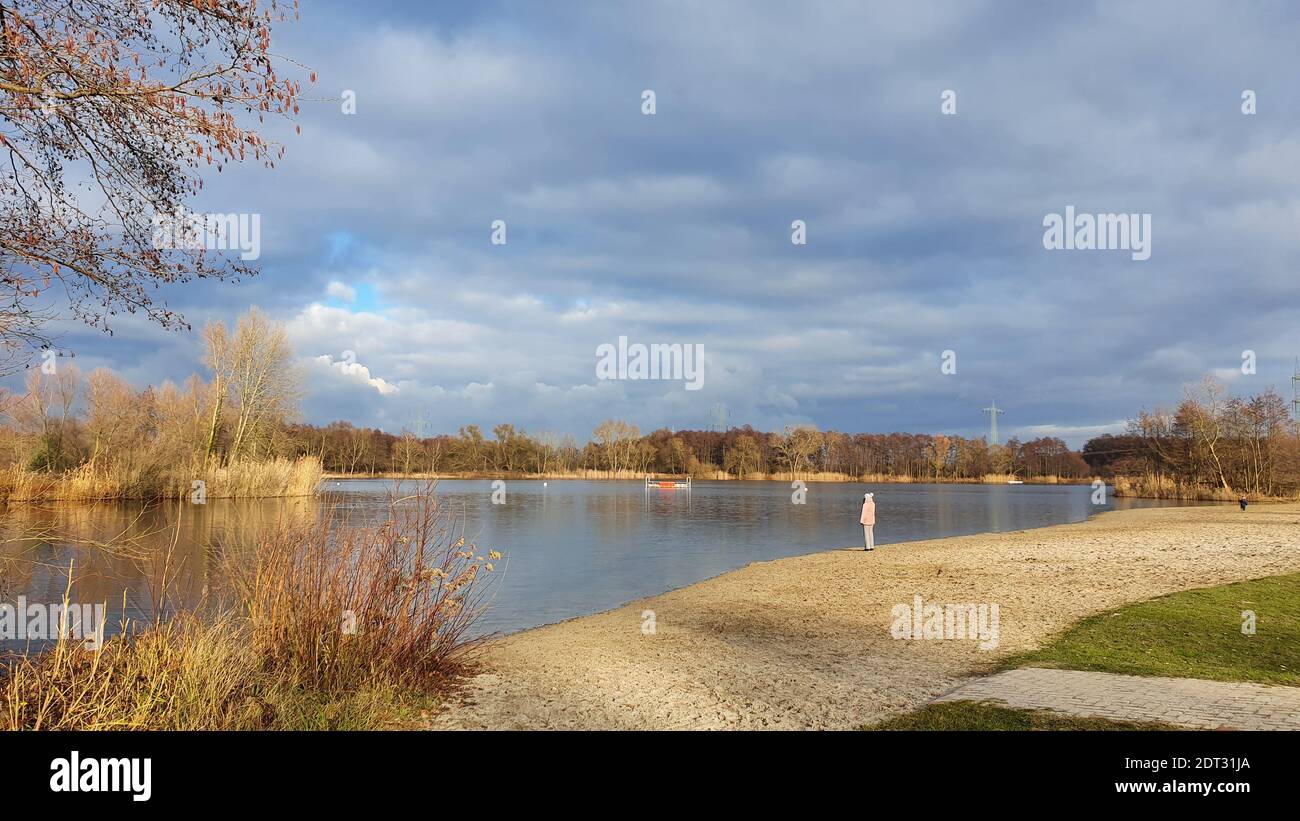 Full Length Of Man Standing By Lake Against Sky Stock Photo