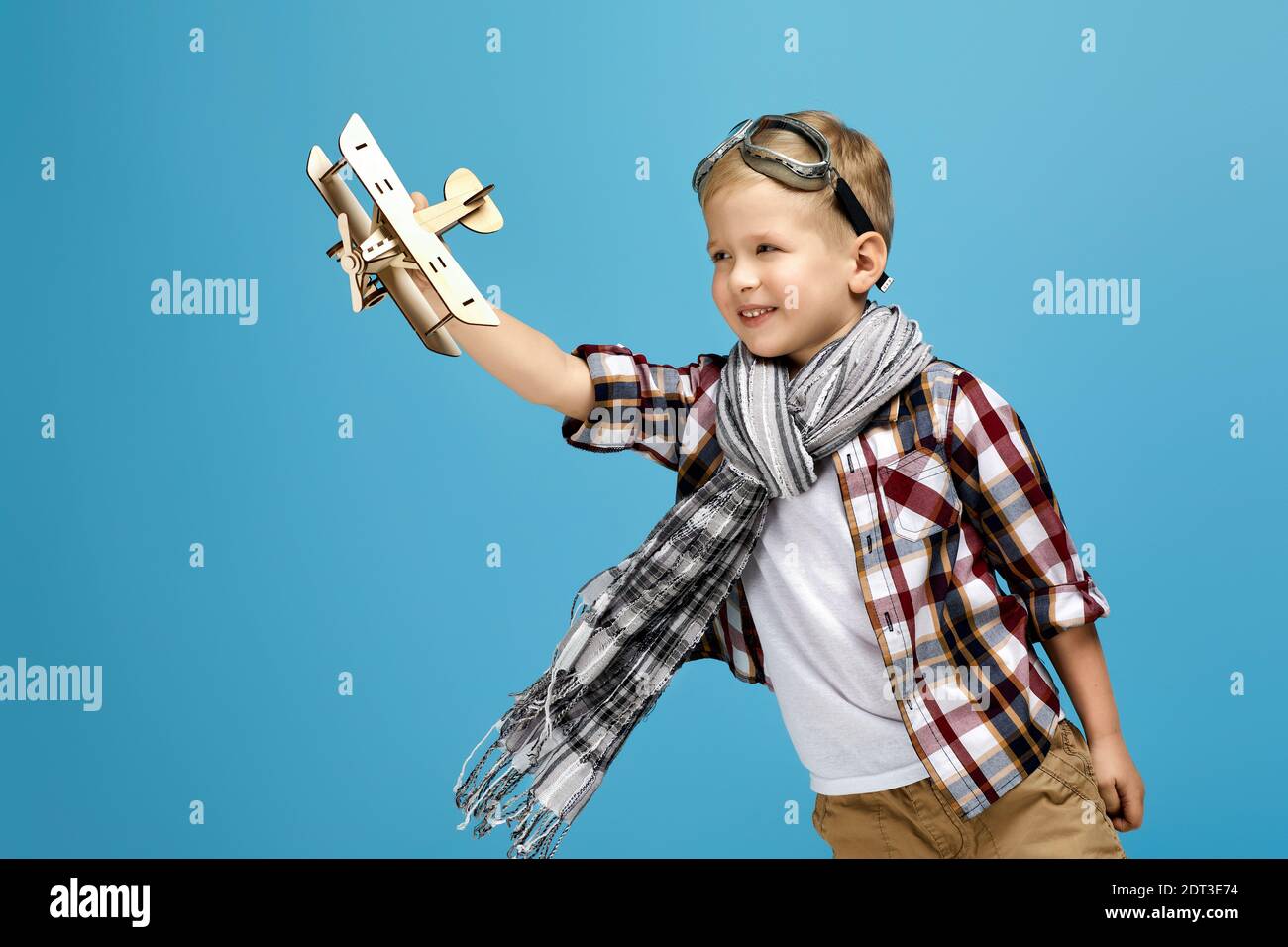 happy child boy in retro glasses and scarf playing with wooden toy ...