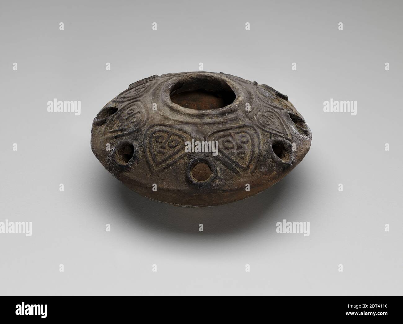 Round lamp with eight holes, 5th–6th century A.D., Terracotta, 10.16 cm (4 in.), The Yale-British School Excavations at Gerasa, Excavated in Gerasa, Jordan, Gerasa (Jordan), Roman, Lighting Devices Stock Photo