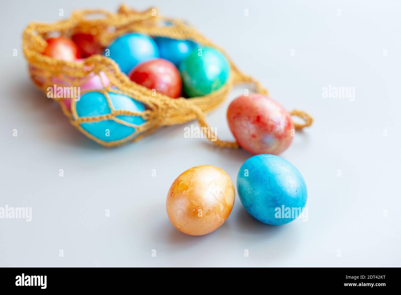 Several multi colored eggs in a knitted bag Stock Photo