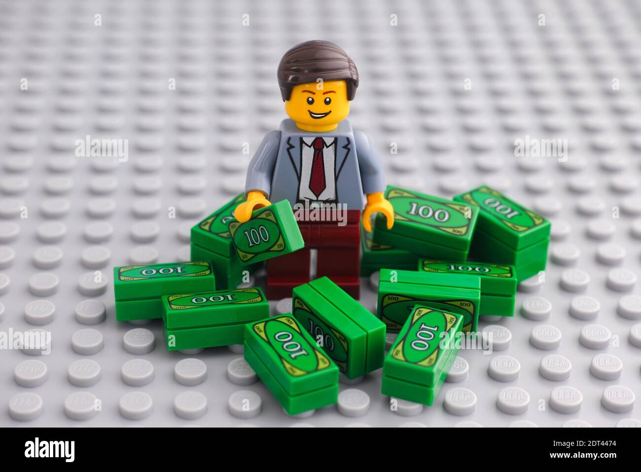 Tambov, Russian Federation - December 19, 2020 Lego businessman minifigure standing in a pile of cash. Stock Photo