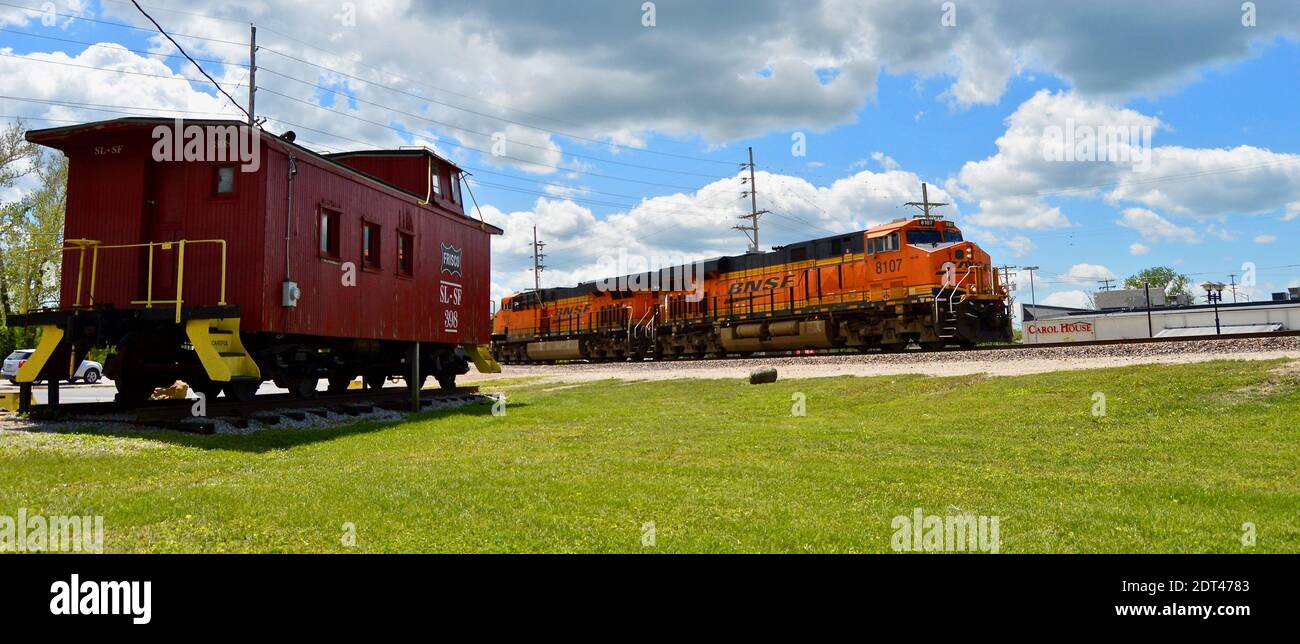 BNSF train passing old caboose in Valley Park, Missouri Stock Photo