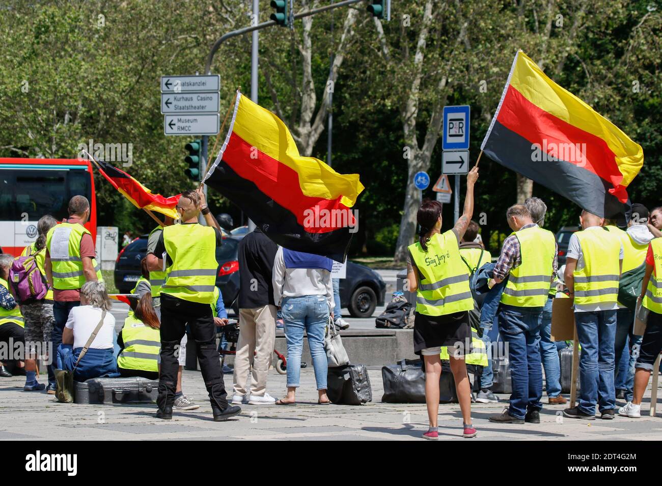 Wiesbaden, Germany. 25th May 2019. Protester wave German flags upside down, a symbol of the Reichsburgerbewegung ("Reich Citizens' Movement"), who reject the modern German state. Under 100 right wing protesters marched with yellow vests through Wiesbaden, to protest against the German government. They were confronted by small but loud counter protest. Stock Photo