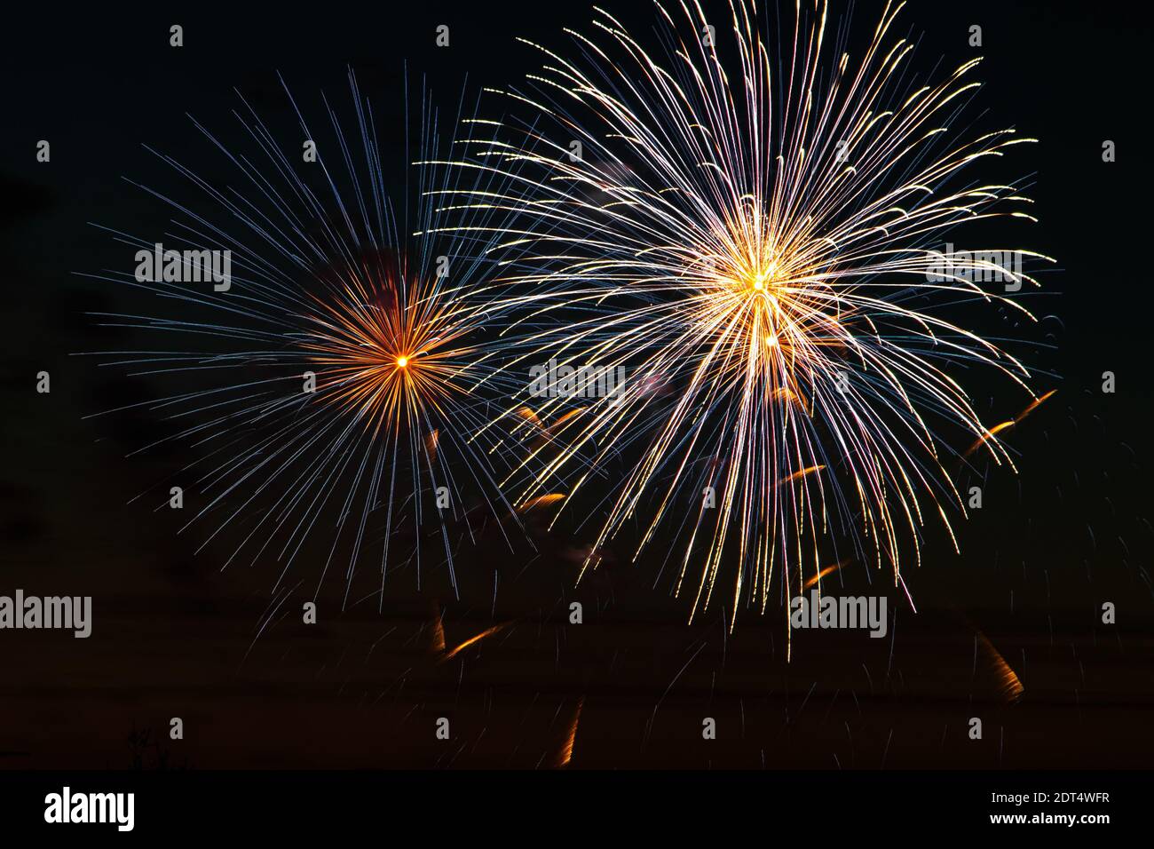 Beautiful festive fireworks in the night sky. Bright multi-colored salute on a black background. Place for text. Stock Photo