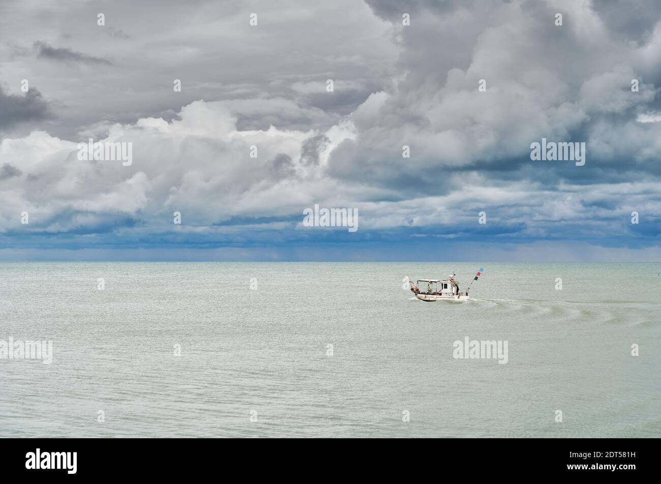 Tiny fisherman boat in a cloudy day of September before the storm, on the venetian coast near Caorle Stock Photo