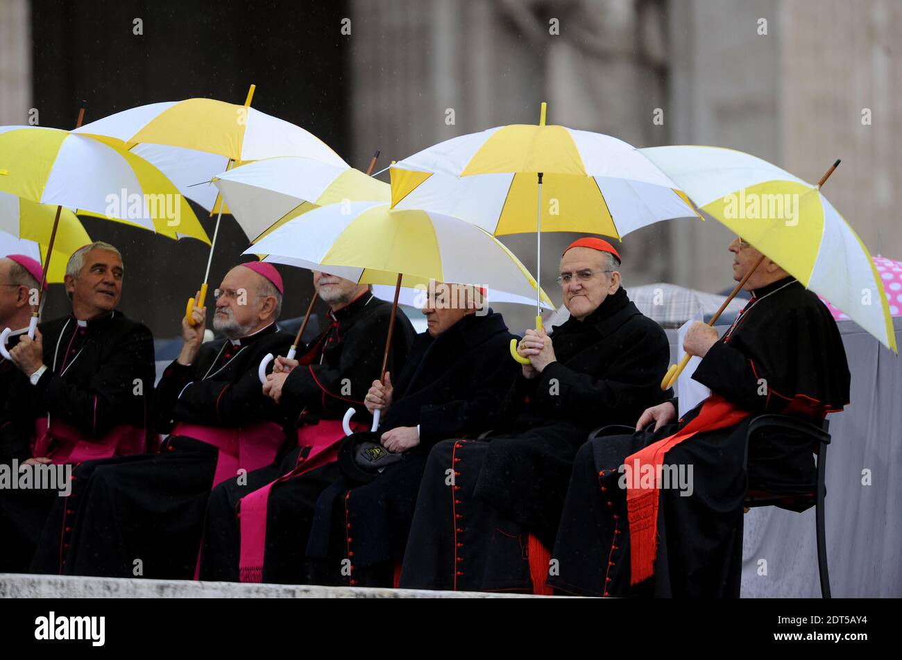 and cardinals protect themselves from the rain with umbrellas during Pope Francis