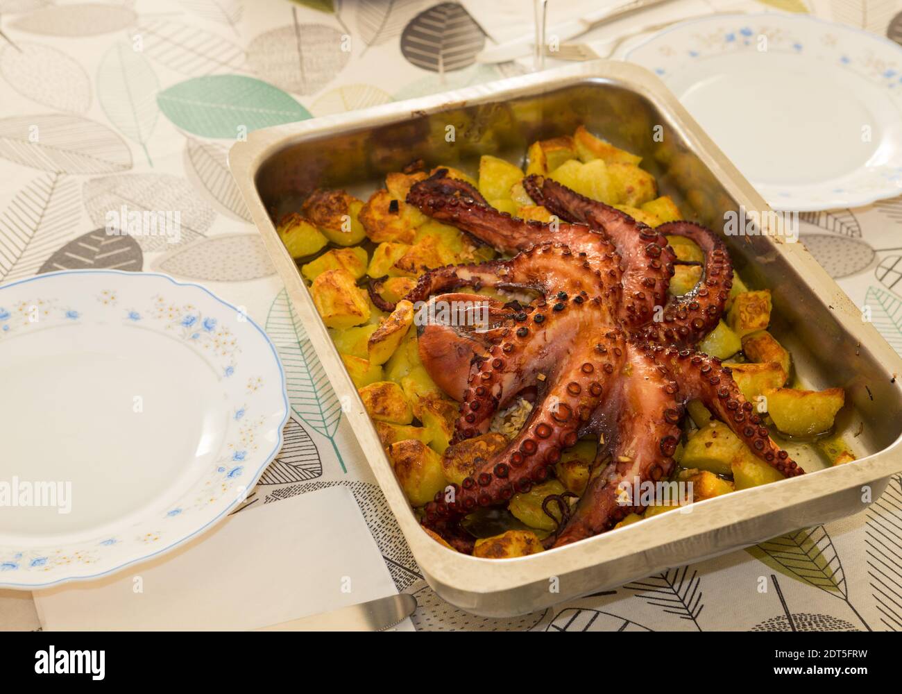 Famous portuguese dish 'Polvo a lagareiro'. Homemade roasted octopus with potatoes ready to eat. Traditional portuguese dish. Stock Photo