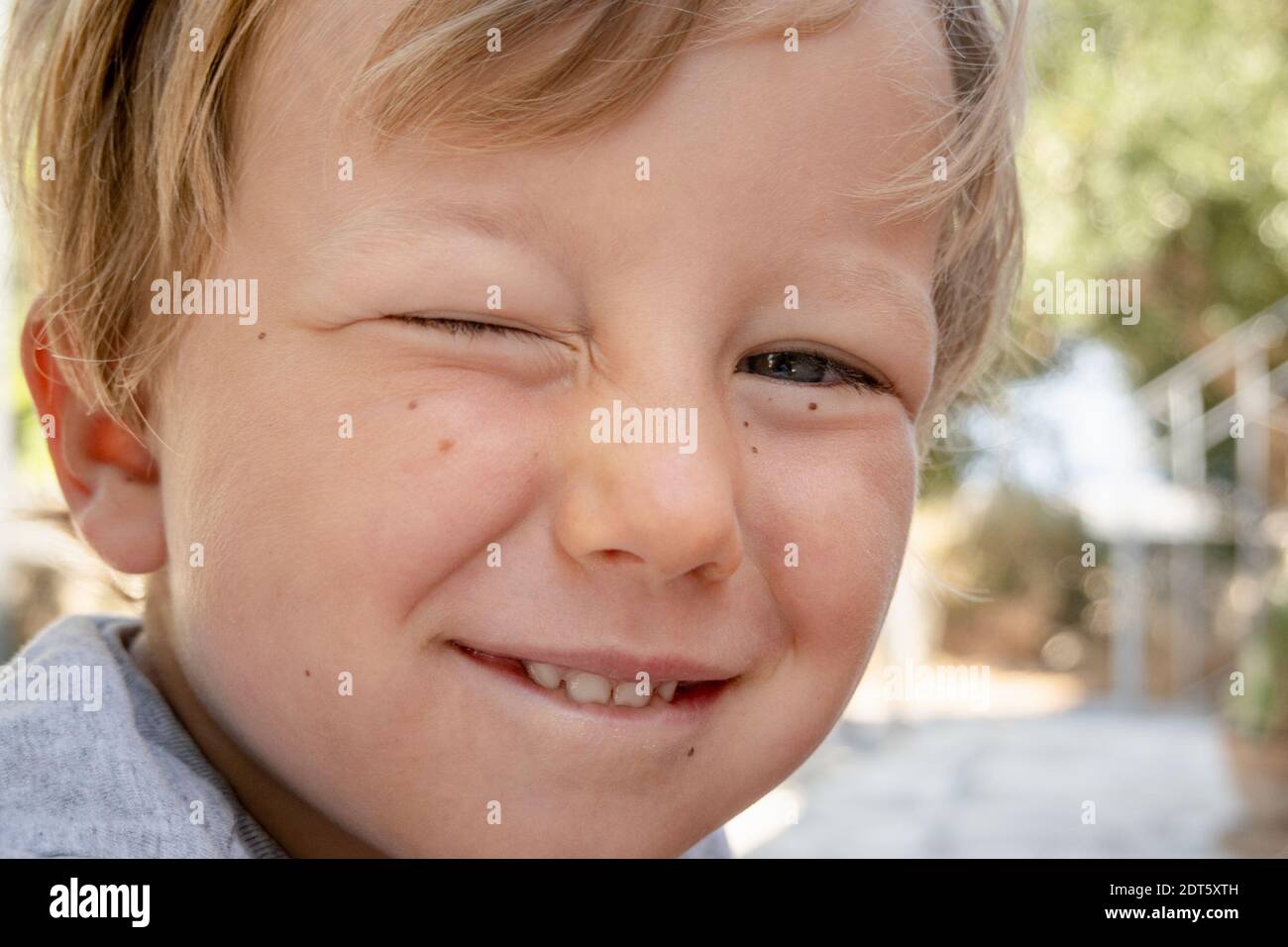 Close-up of boy winking with eyes Stock Photo